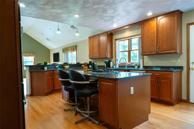 a kitchen with stainless steel appliances granite countertop sink stove and refrigerator