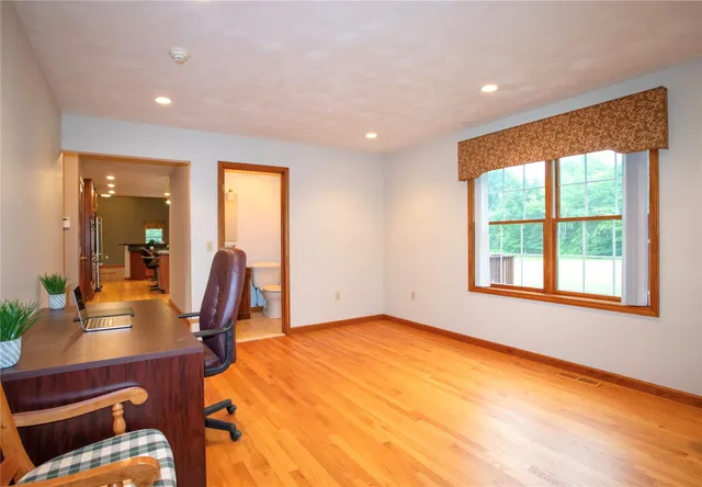 a view of a workspace with furniture and a window