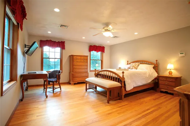 a bedroom with furniture and a large window