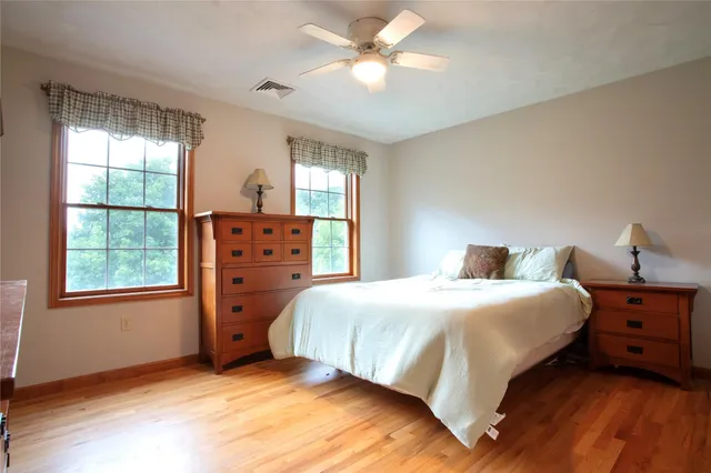 a bedroom with a bed dresser and a window