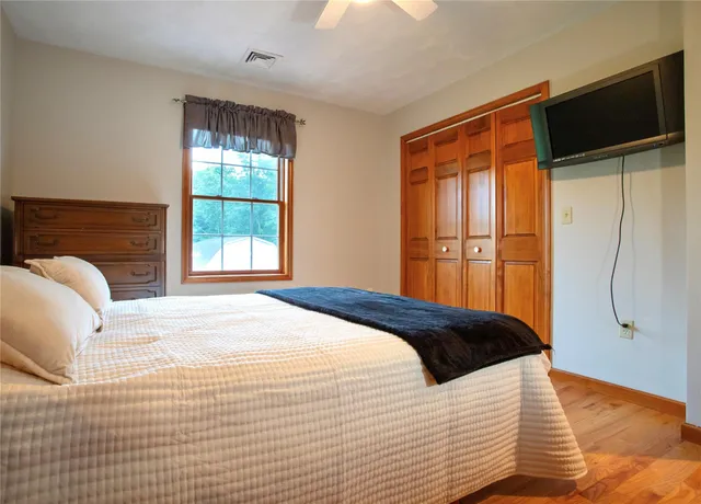 a bedroom with a bed and a flat tv screen