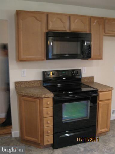 17321 Three Notch Road Dameron, MD 20628 - Photo 3 of 8 a kitchen with a stove and a microwave