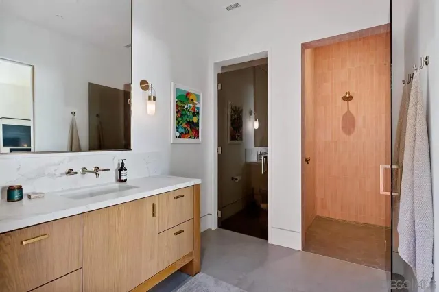 a spacious bathroom with a double vanity sink mirror and shower