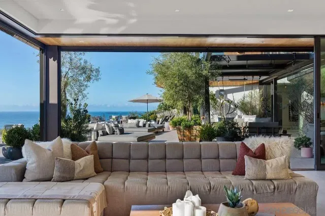 a living room with furniture floor to ceiling window and a flat screen tv