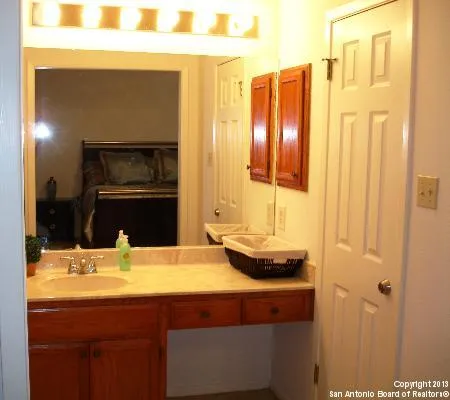 a bathroom with a granite countertop sink and a large mirror