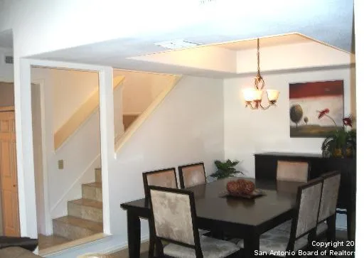 a view of a dining room with furniture a chandelier and wooden floor
