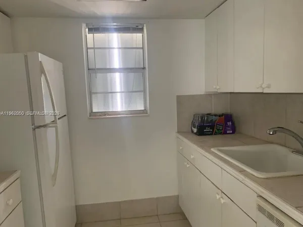a kitchen with a refrigerator and cabinets
