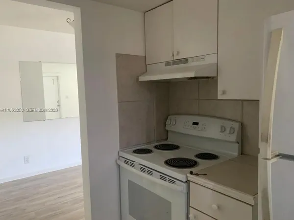 a room with a refrigerator and cabinets