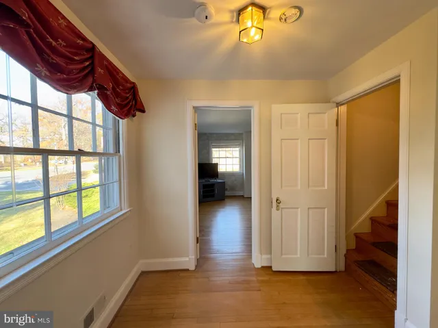 a view of hallway with livingroom and wooden floor
