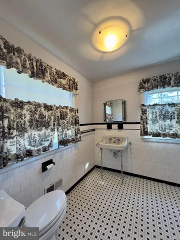 a bathroom with a sink a toilet and mirror