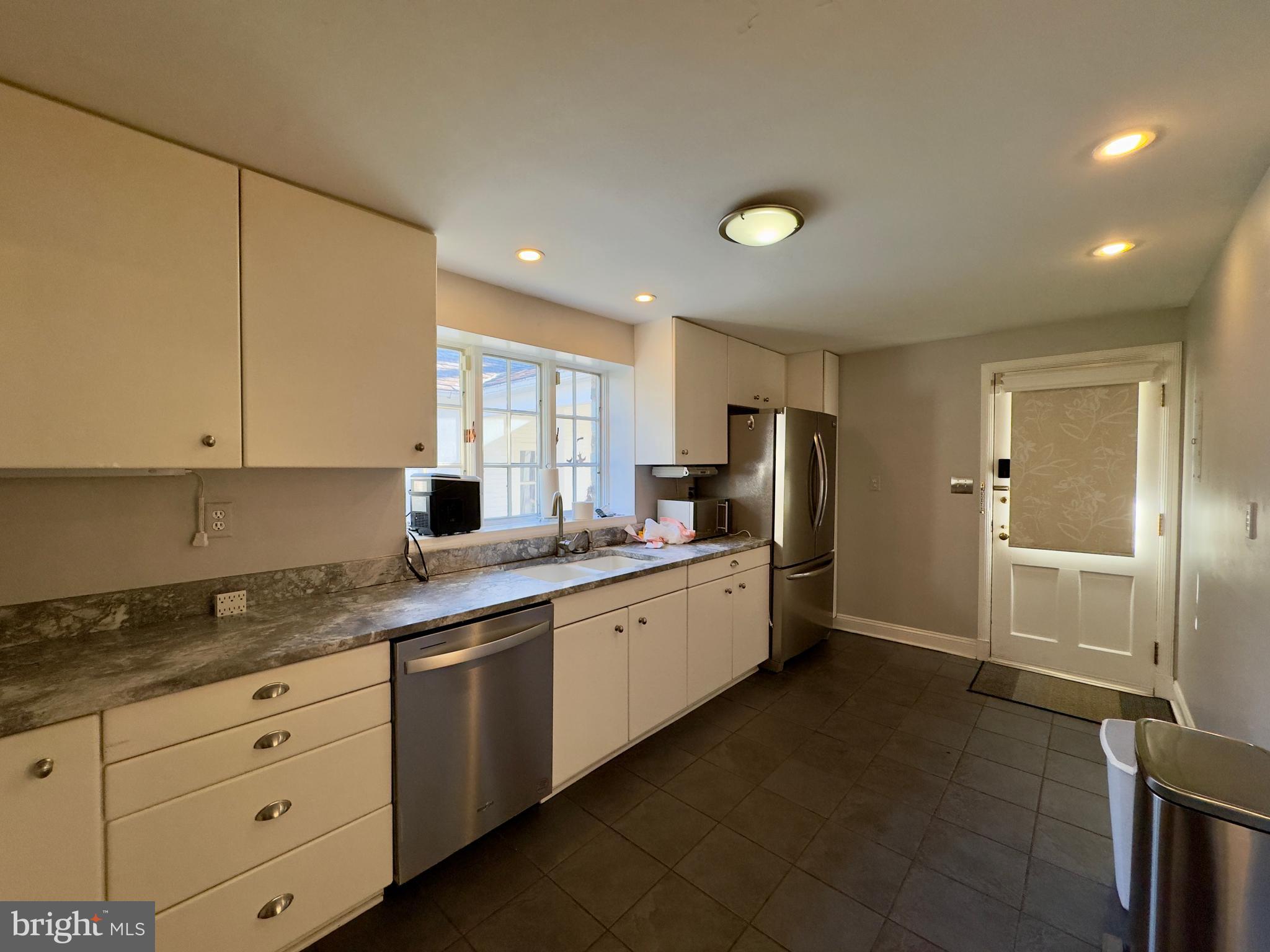 5113 North Charles Street Baltimore, MD 21210 - Photo 29 of 34 a kitchen with granite countertop a refrigerator and white cabinets