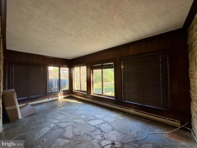 a view of an empty room with a fireplace and a window