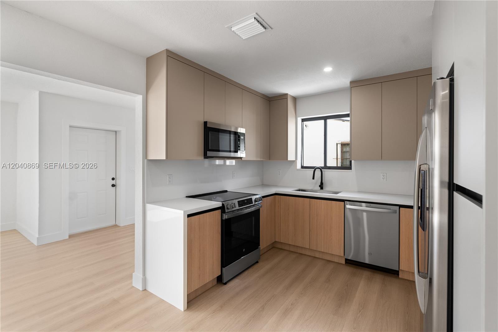 31 West 64th Street Hialeah, FL 33012 - Photo 20 of 49 a kitchen with stainless steel appliances granite countertop a stove top oven a sink and a refrigerator