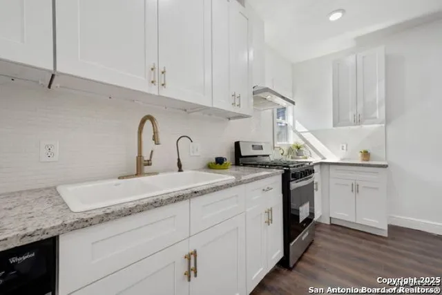 a kitchen with granite countertop white cabinets and white appliances