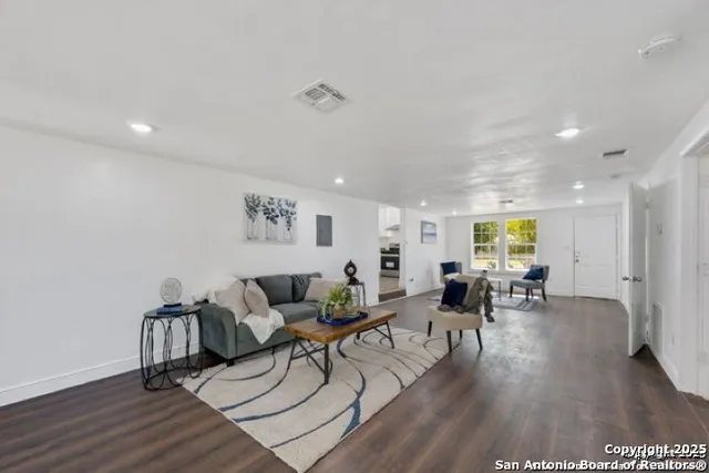 a living room with furniture and wooden floor