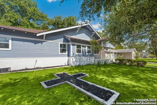 a front view of a house with a yard and trees