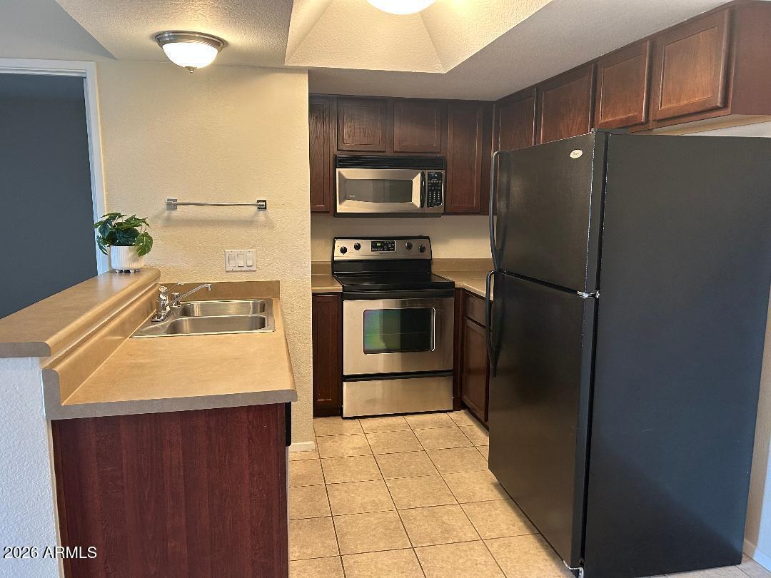 1720 East Thunderbird Road, Unit 2068 Phoenix, AZ 85022 - Photo 5 of 10 a kitchen with stainless steel appliances a refrigerator and a stove