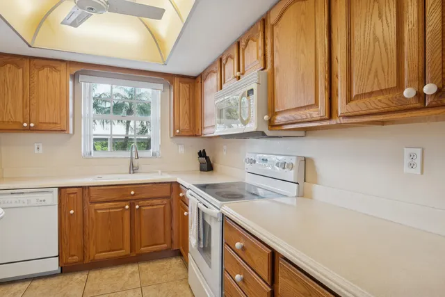 a kitchen with stainless steel appliances granite countertop a sink and a white cabinets