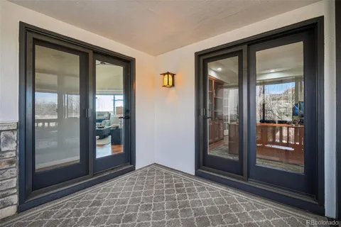 a view of a roof deck with table and chairs couches with wooden floor and fence