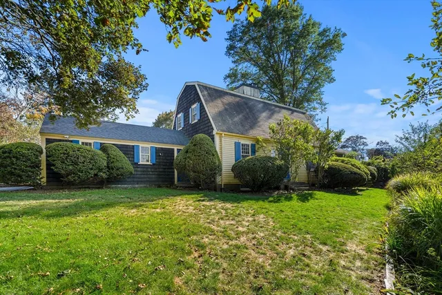 a view of a house with a yard and potted plants
