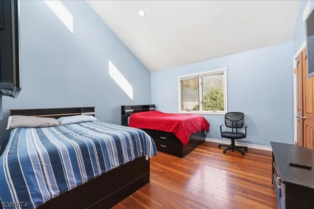 a bedroom with bed and wooden floor