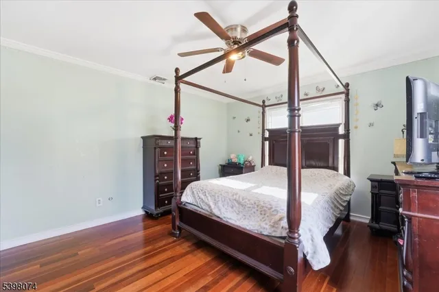 a bedroom with a bed a table and wooden floor