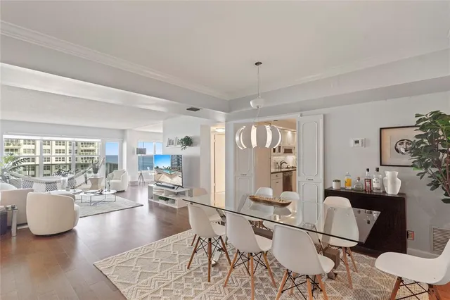 a living room with furniture a potted plant and a large window