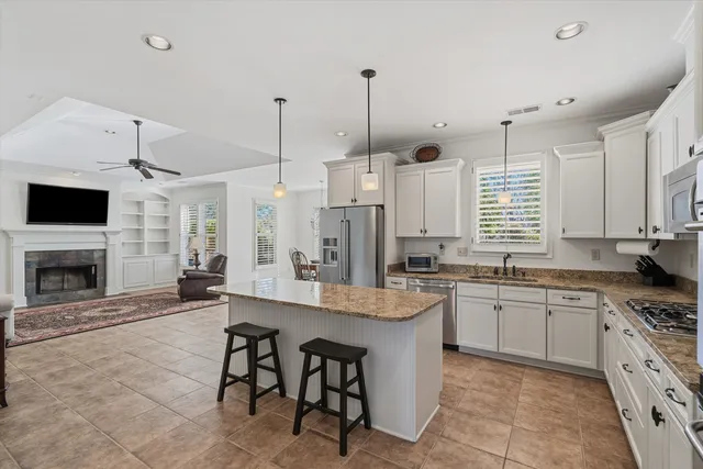 a large kitchen with stainless steel appliances kitchen island granite countertop a sink and cabinets