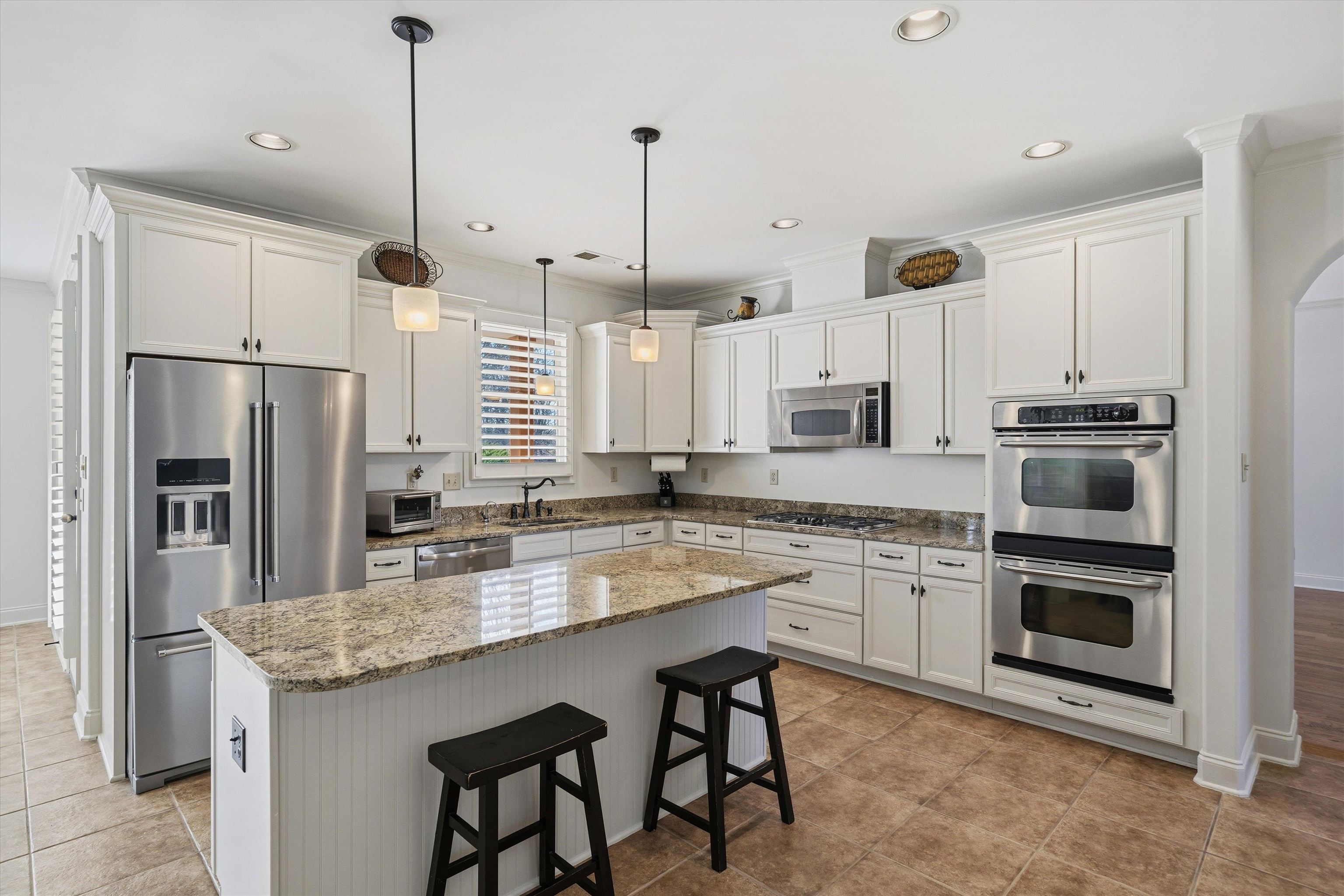 639 Critz Cove Collierville, TN 38017 - Photo 14 of 40 a kitchen with stainless steel appliances granite countertop a stove a sink island and a refrigerator