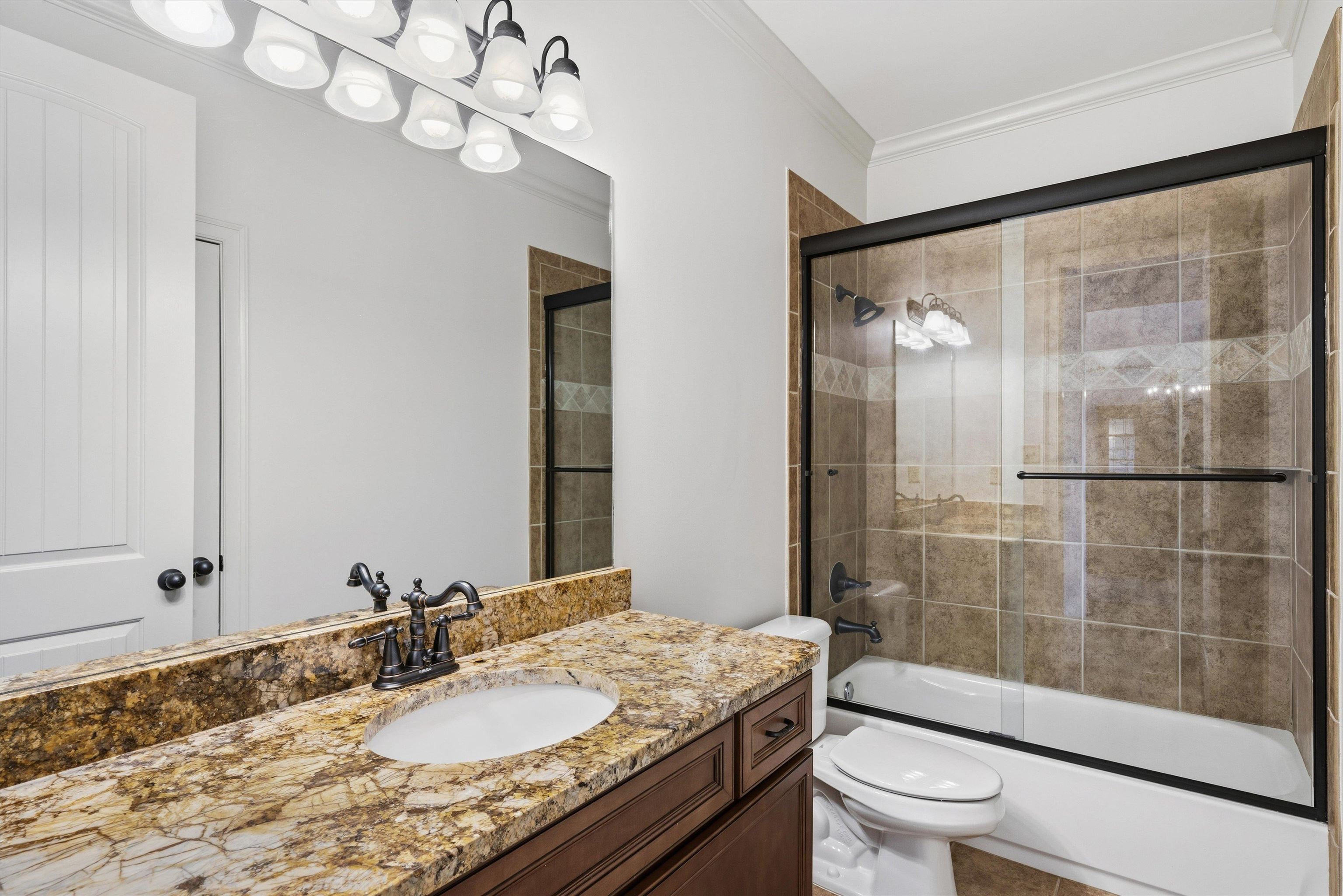 639 Critz Cove Collierville, TN 38017 - Photo 26 of 40 a bathroom with a granite countertop sink a toilet a mirror and shower