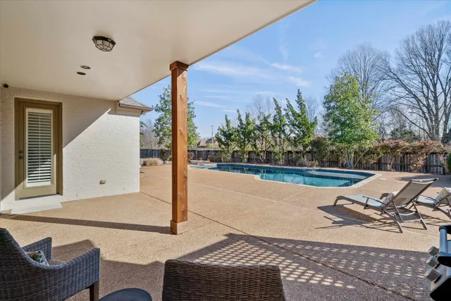 a view of swimming pool with seating space and fir pit