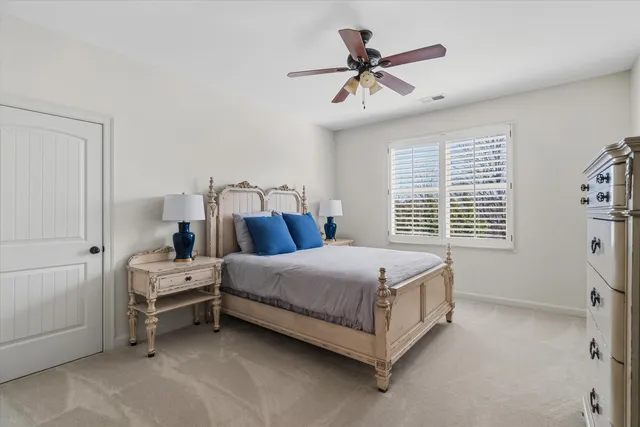 a bed room with a bed and a ceiling fan