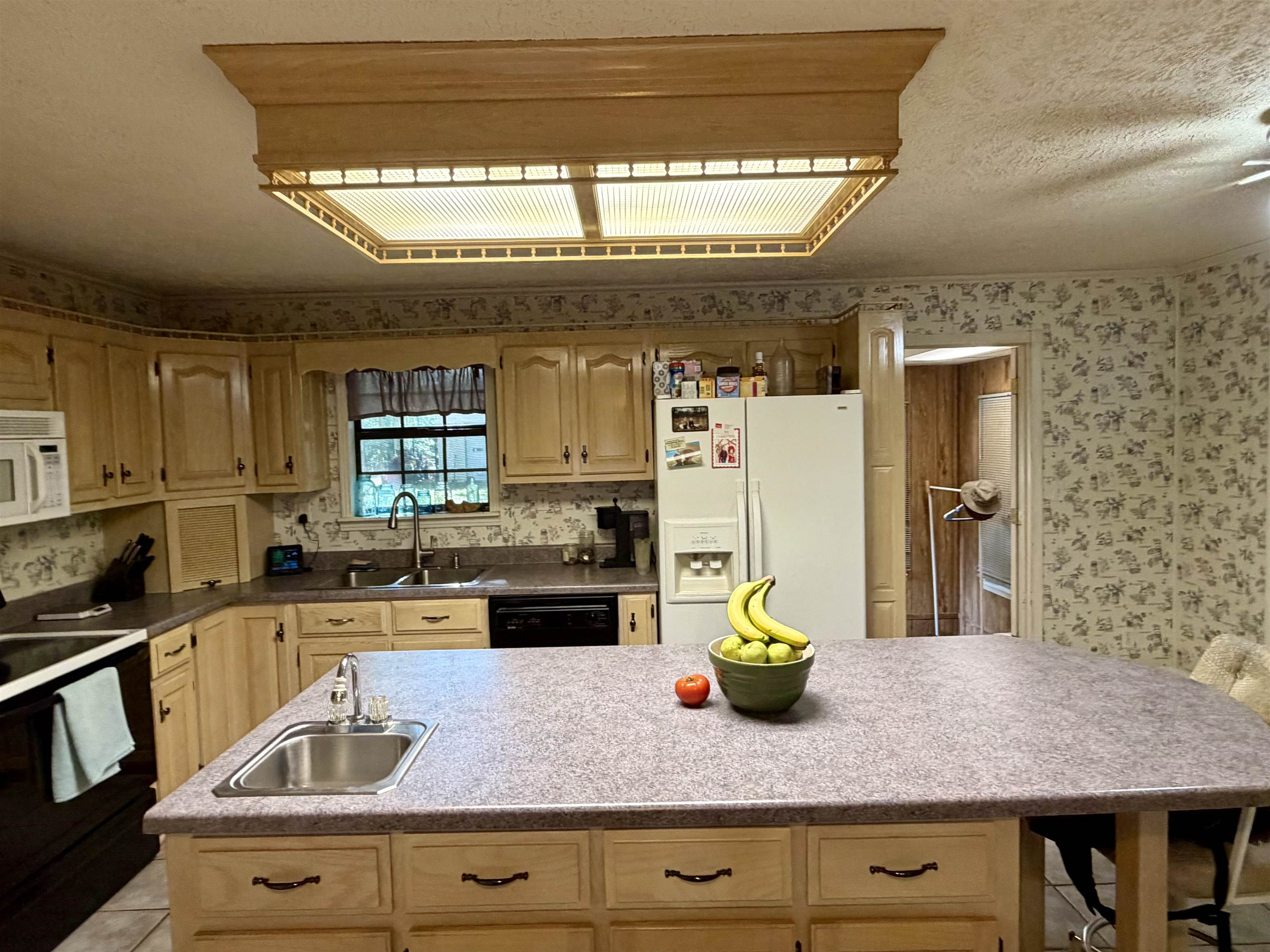 373 Clarence Barham Road Bethel Springs, TN 38315 - Photo 9 of 28 Kitchen featuring light wood cabinetry, a central island with an integrated sink, laminate countertops, and a built-in electric stove