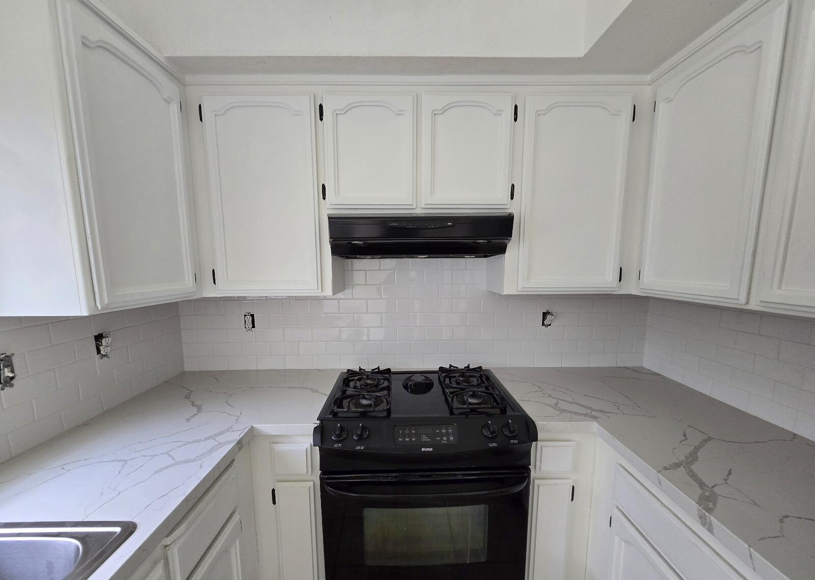 454 Alamine Drive Redding, CA 96003 - Photo 13 of 28 a kitchen with granite countertop white cabinets and black appliances