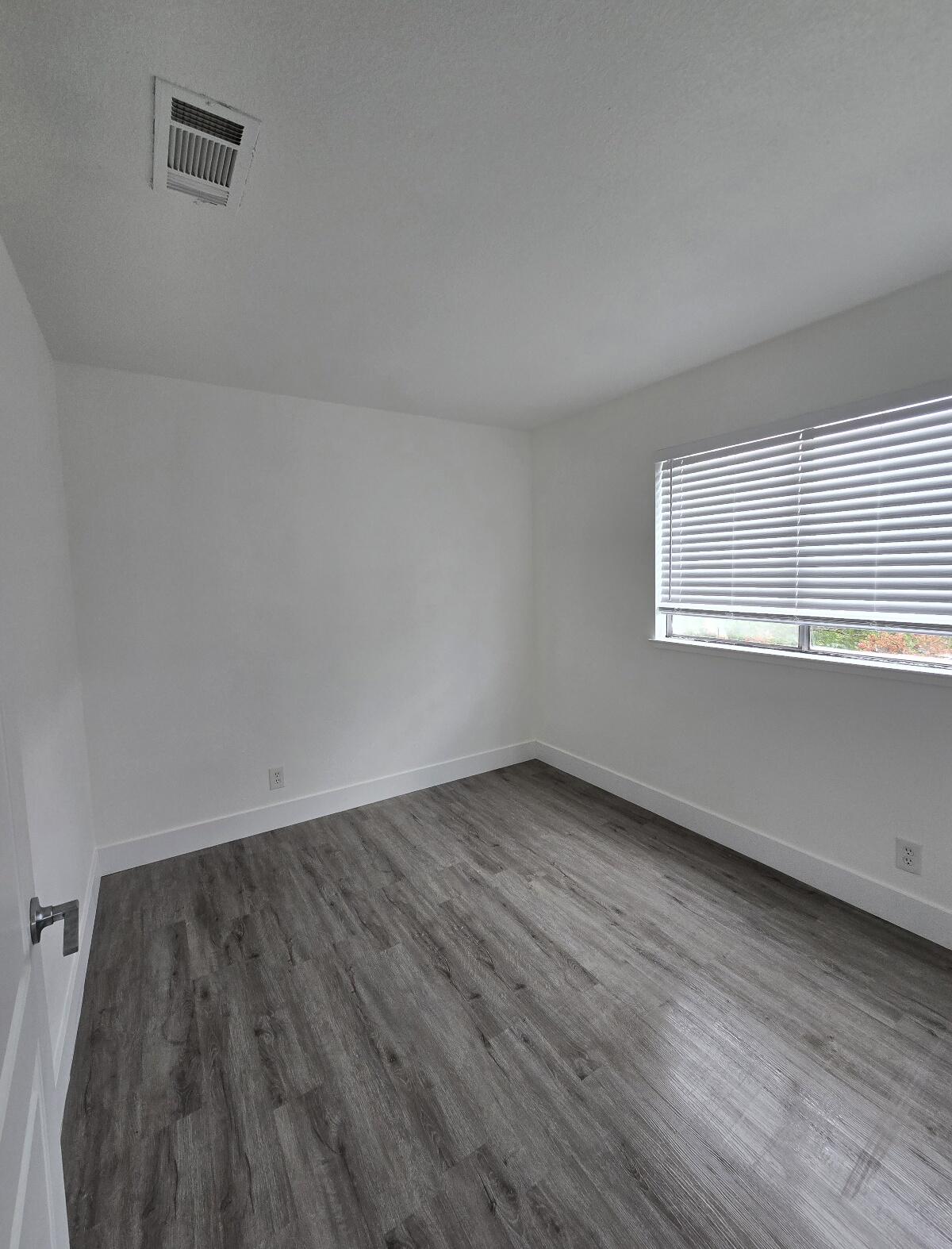 454 Alamine Drive Redding, CA 96003 - Photo 23 of 28 an empty room with wooden floor and windows