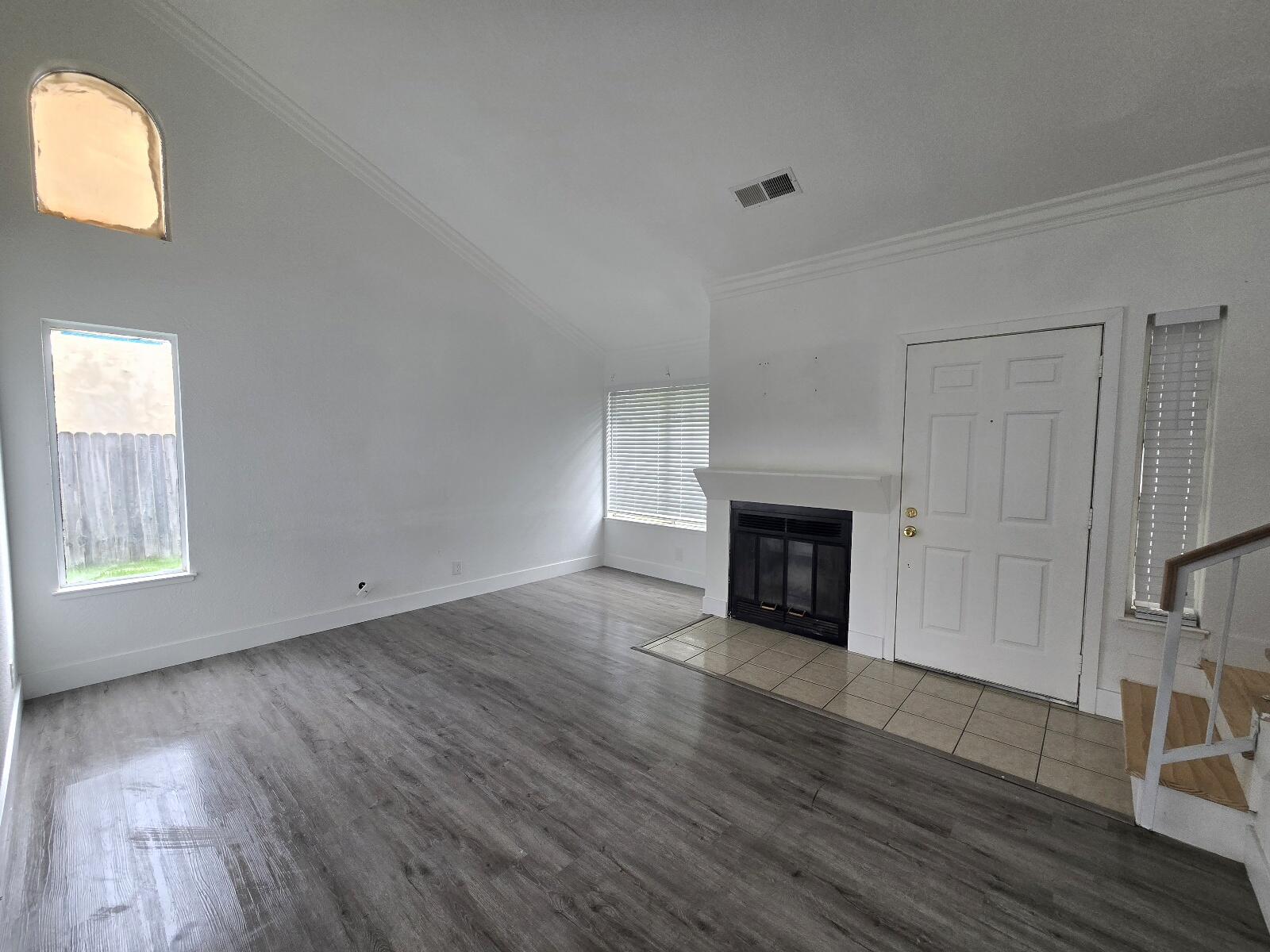 454 Alamine Drive Redding, CA 96003 - Photo 6 of 28 an empty room with wooden floor fireplace and windows