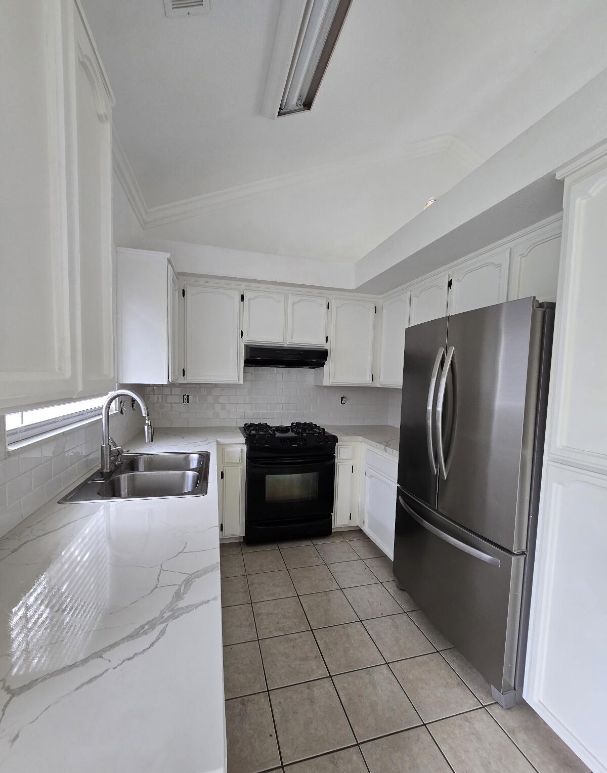 454 Alamine Drive Redding, CA 96003 - Photo 10 of 28 a kitchen with granite countertop a refrigerator and a sink