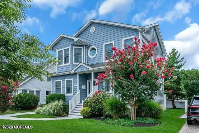 a front view of a house with a yard and trees