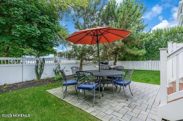 a view of a backyard with table and chairs under an umbrella