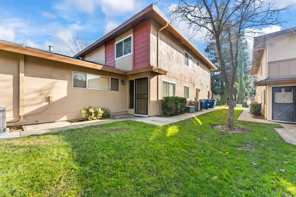 a view of a house with a yard and sitting area