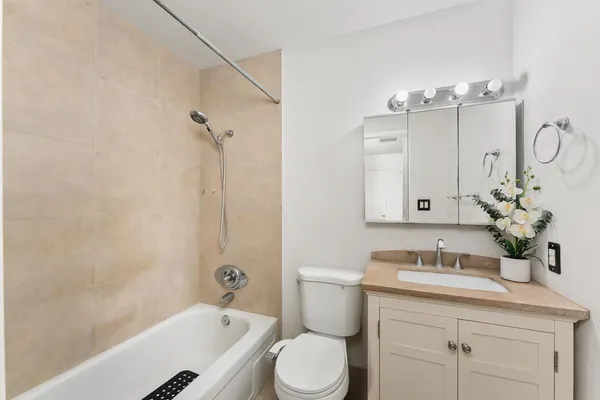 a bathroom with a granite countertop sink a toilet and shower