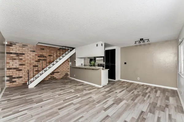 a view of a kitchen with wooden floor and stairs