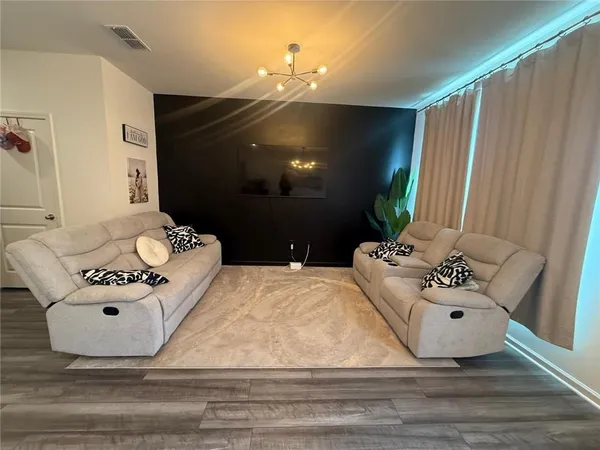 a living room with furniture and a chandelier