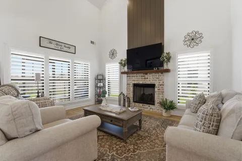 a living room with furniture a flat screen tv and a fireplace