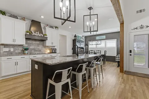 a kitchen with a table chairs stove and cabinets