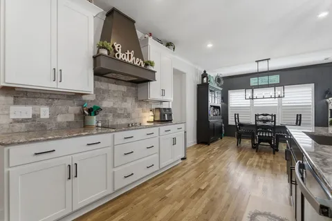 a kitchen with granite countertop white cabinets and white appliances