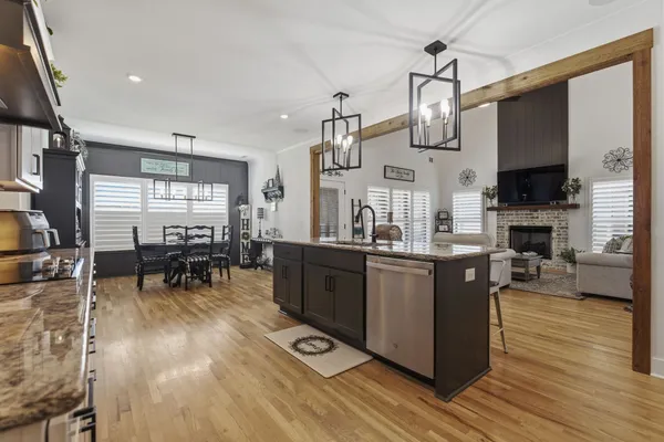 a kitchen with stainless steel appliances granite countertop a stove and a wooden floors