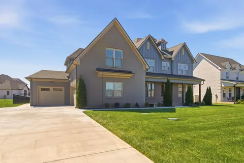 a front view of a house with a yard and trees