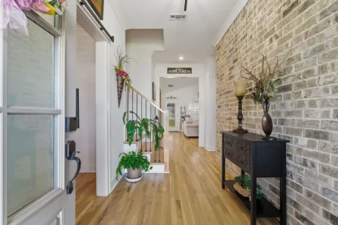a view of a hallway with wooden floor and a potted plant