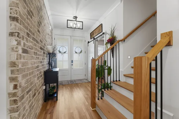a view of hallway with wooden floor and stairs